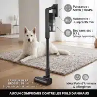 Dyceros Un chien blanc est assis sur un tapis avec l'Aspirateur balai sans fil Dyceros AS700 (500W, technologie cyclonique, brosse spéciale poils d'animaux), offrant 18kPa d'aspiration, 35 min d'autonomie, un bac de 0,7L et une brosse de 25cm pour un nettoyage facile.